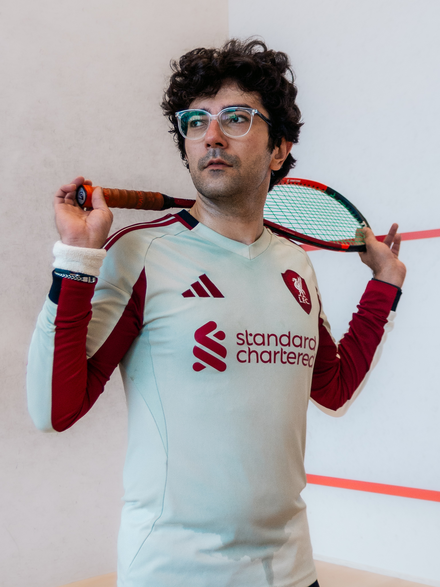 Portrait of a squash player holding a racket across his shoulders