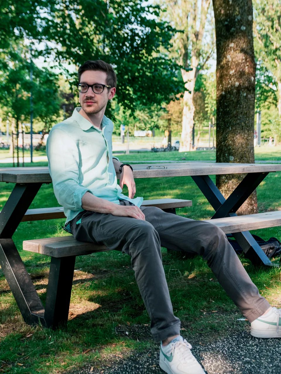 Outdoor portrait of a man in glasses seated at a picnic table